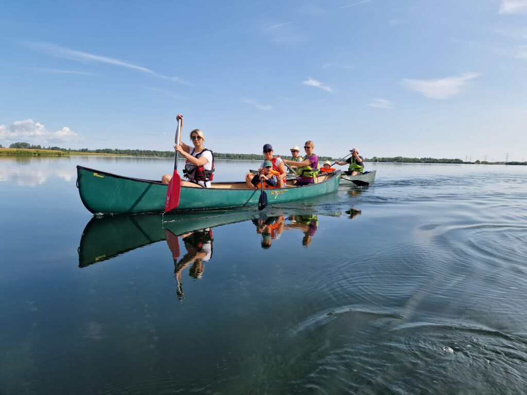 Zwei Gruppen fahren Kanu auf einem See.