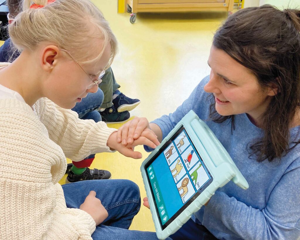 Mädchen lernt zusammen mit einer Frau an einem Tablet.